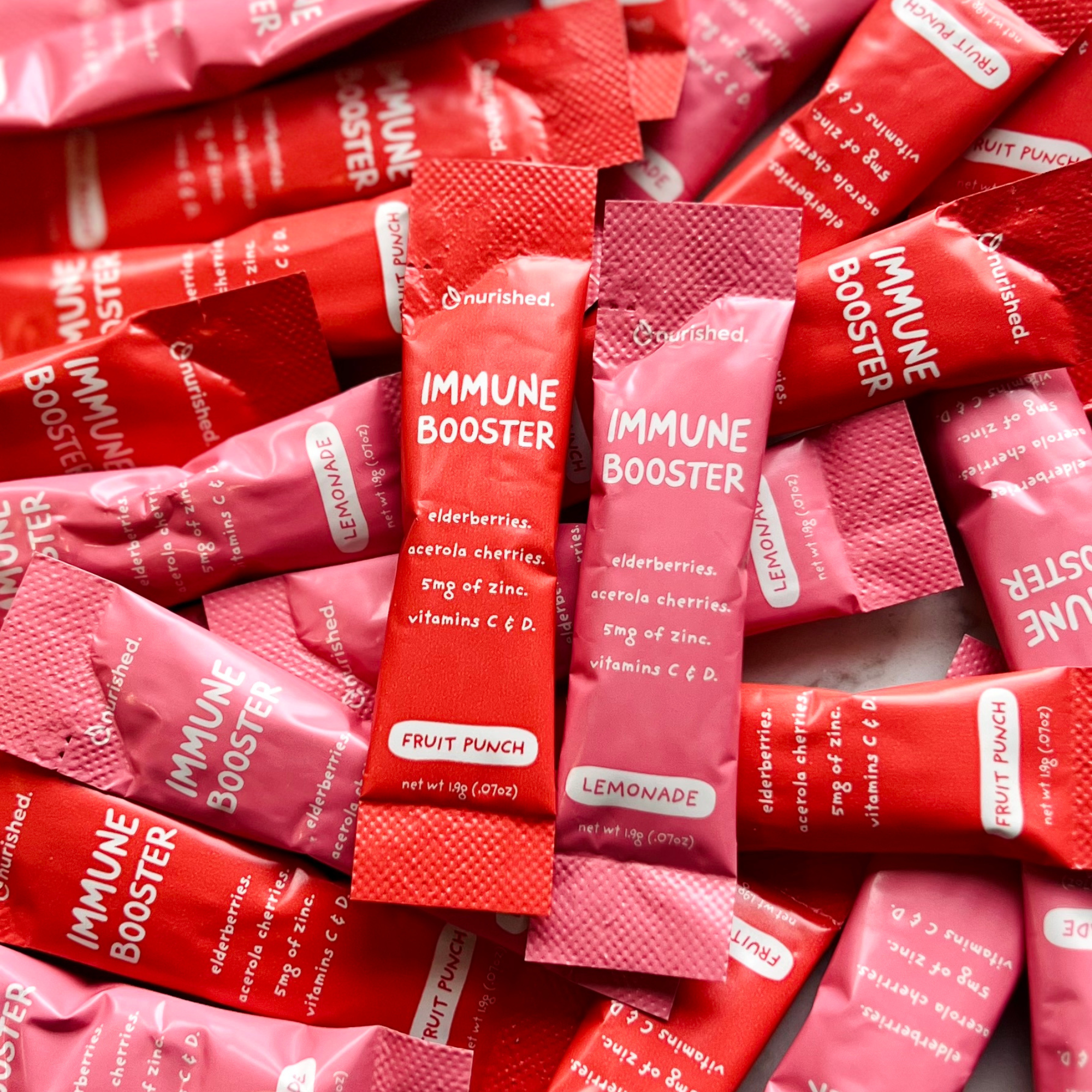 close up of a pile of immune booster stick packs in red and pink packaging