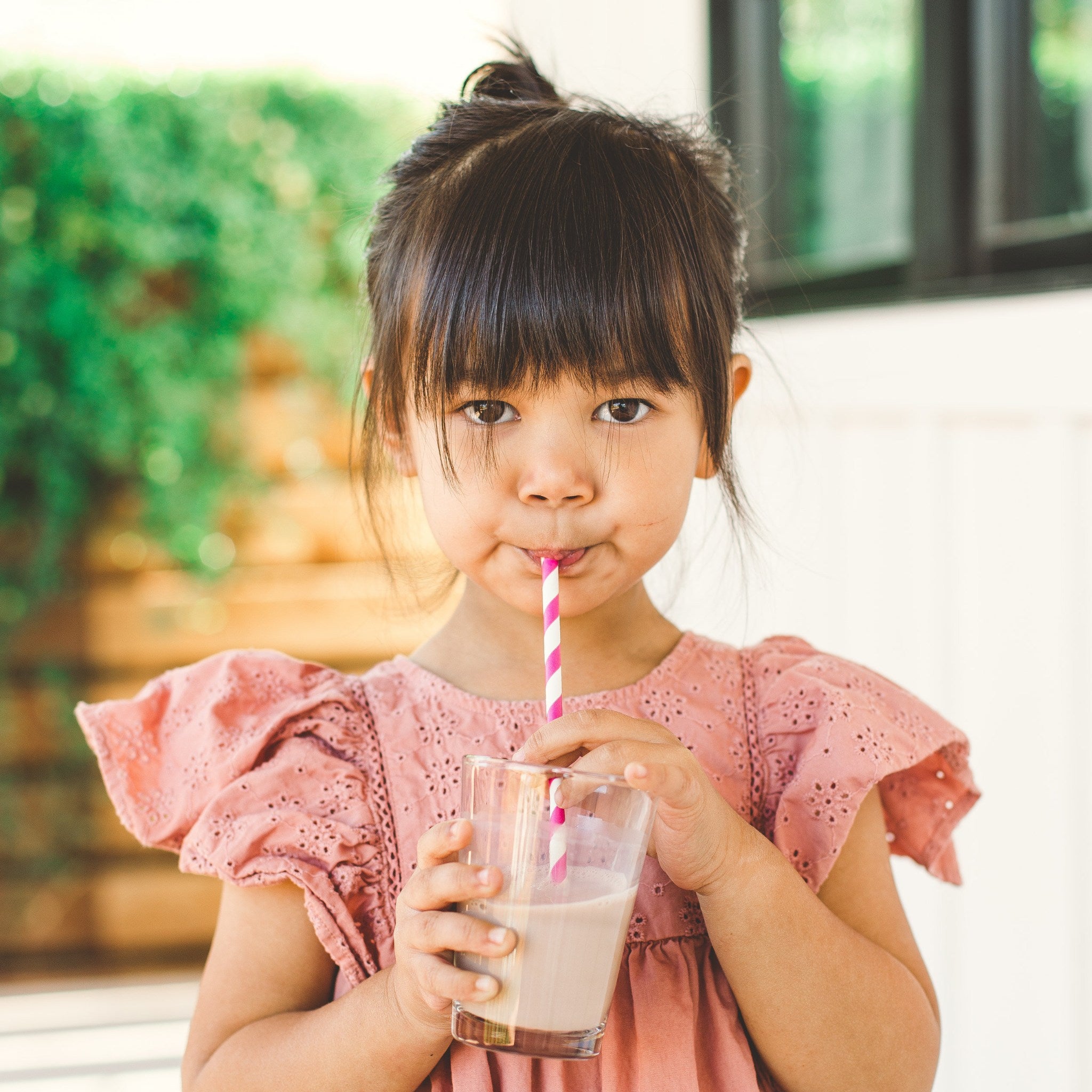 young girl drinking glass of mighty milk