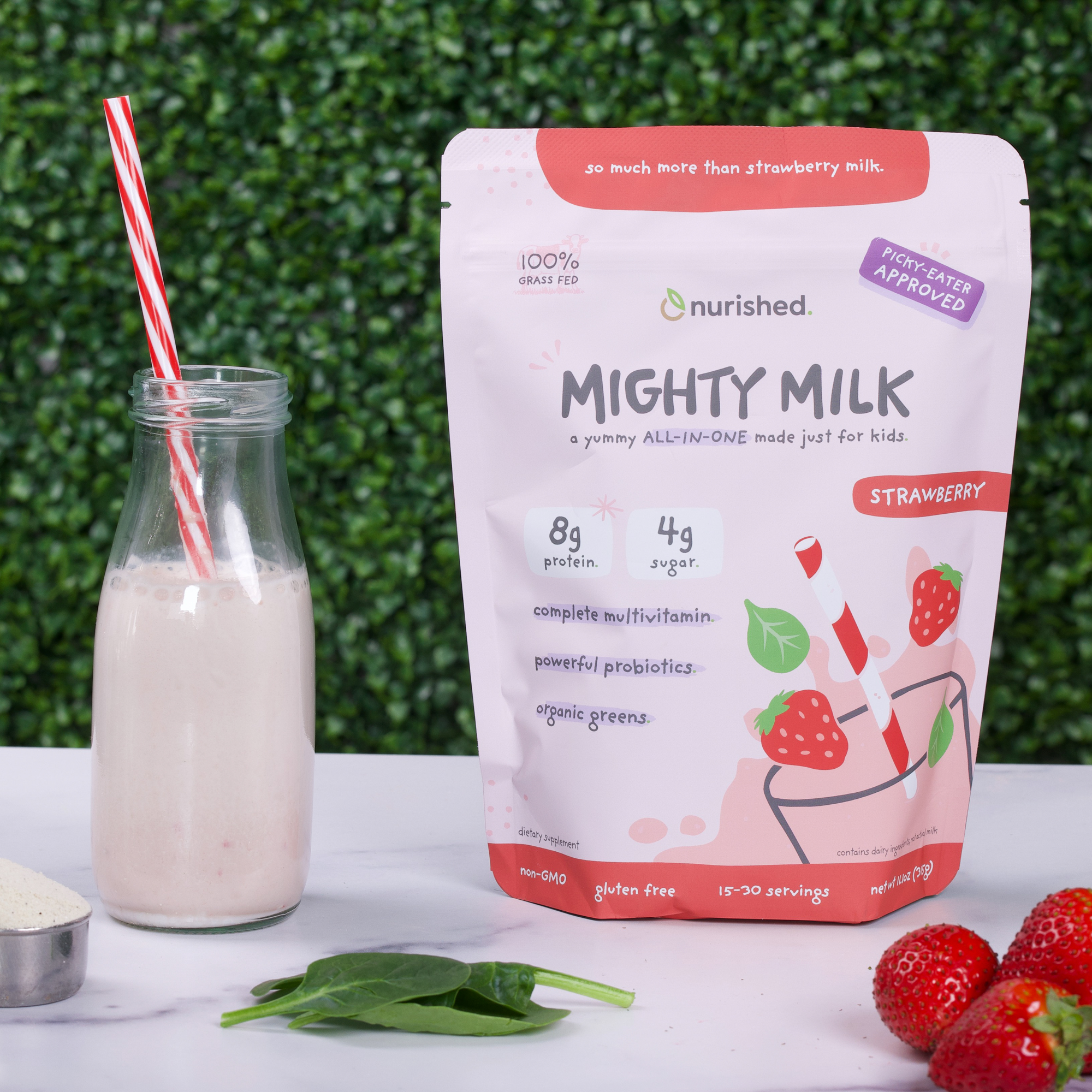 Strawberry Mighty Milk Pouch next to a glass of it with a straw